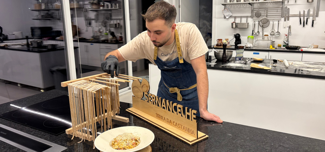 Um cozinheiro a preparar um prato numa cozinha moderna.